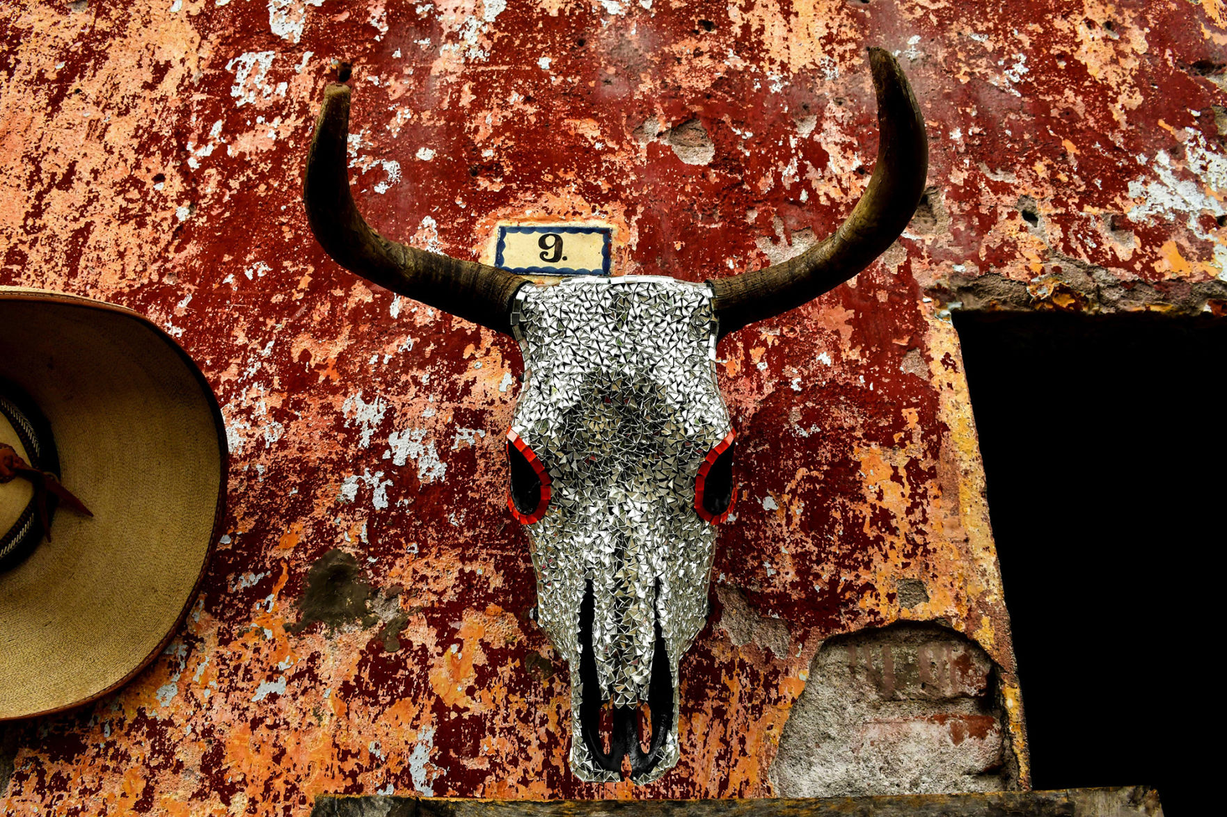 The owner of this antiques shop was standing about two feet away when I spotted this decorated skull. I asked permission to shoot, he welcomed the picture, and I stepped up to fill the frame. Rain helped deepen the colors.